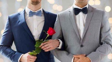Homoseksuelt brudepar i hhv blåt og gråt jakkesæt. Den ene med en rød rose. Brystbillede. Ansigterne ses ikke.